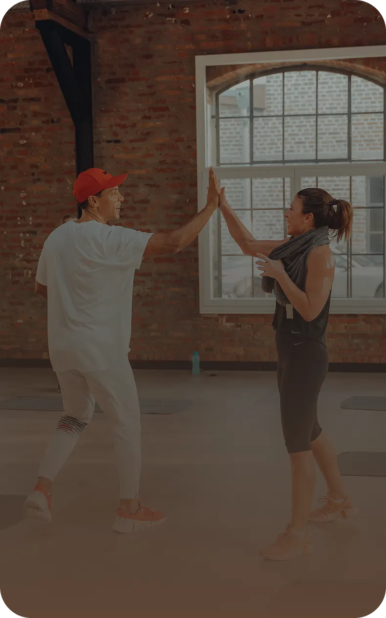 Zwei Personen geben sich High-Five im Peoples Fitness Studio – Gemeinschaft und Motivation