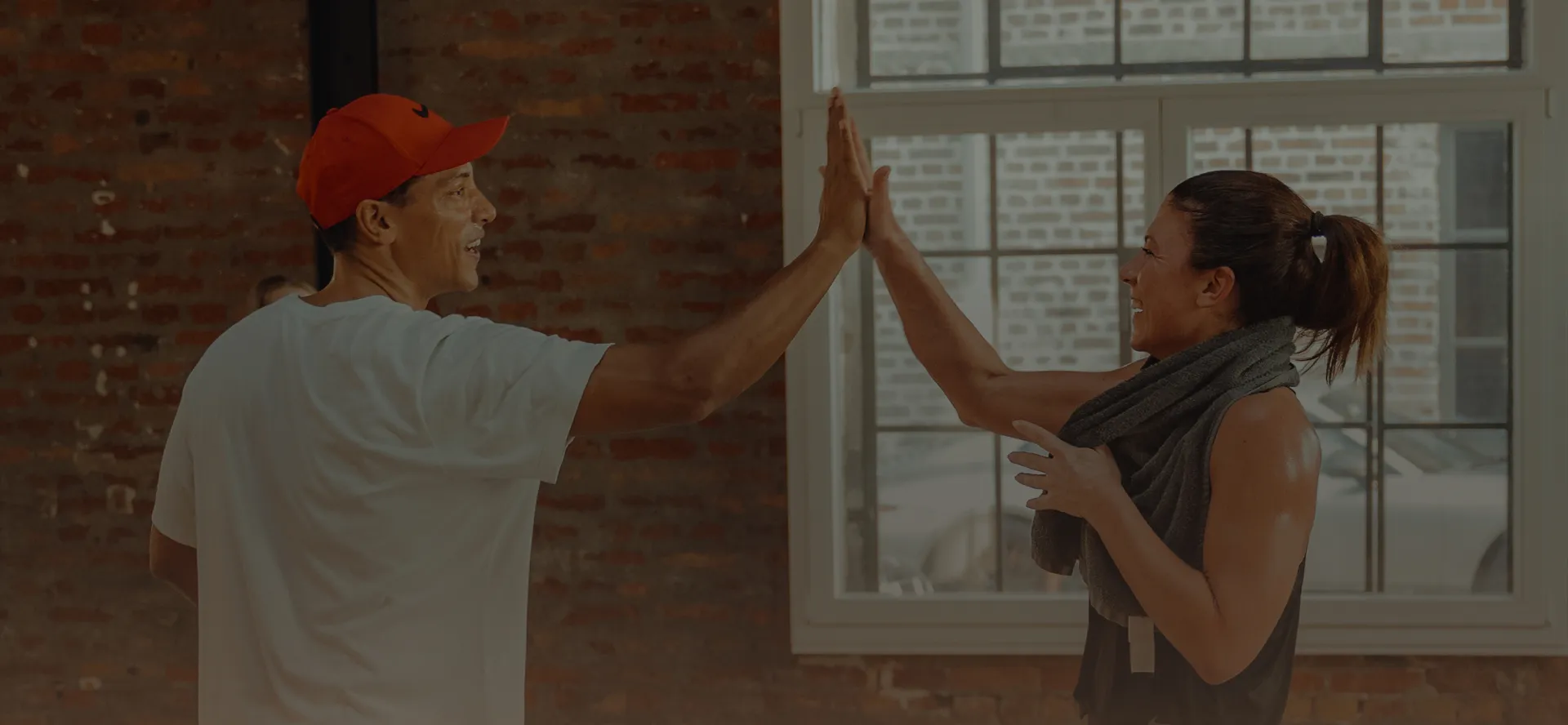Zwei Personen beim High-Five im peoples Fitness Studio